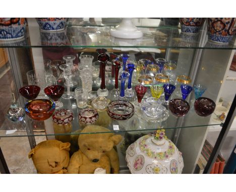 A shelf of colourful glassware.