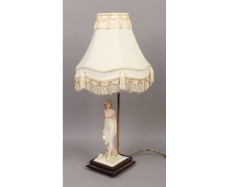 An Italian figural table lamp of a woman with headdress.