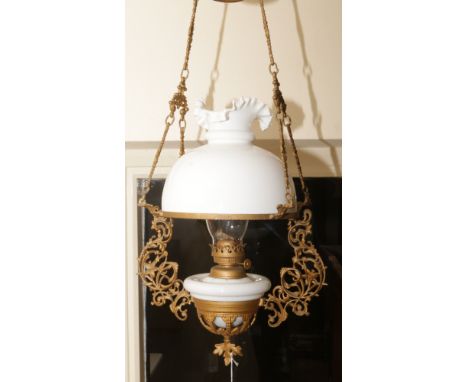 A Victorian gilt metal hanging oil lamp with milchglas burner and shade.