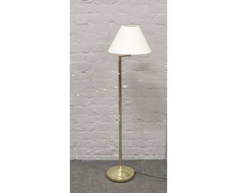 A brass adjustable standard lamp with shade.