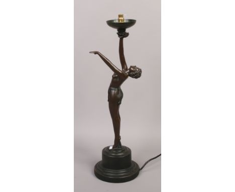 An Art Deco style table lamp of a semi nude woman raised on a circular plinth.