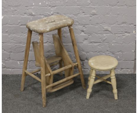 A vintage folding step stool, along with a painted milking stool.