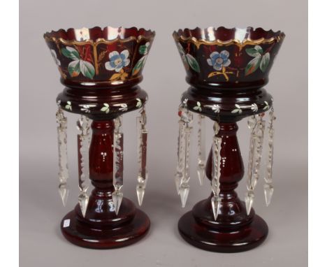 A pair of early 20th century ruby glass lustres with enamel floral decoration and gilt edging.