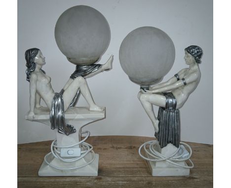 A pair of modern composite Art Deco style figural lamps depicting female nudes holding spherical shades, tallest 49cm.