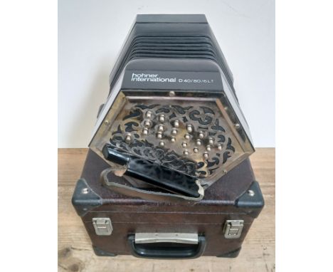 A Hohner International D40/80/6LT concertina squeeze box with associated hard case.Condition:- General wear throughout with n