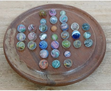 A solitaire board containing 33 hand blown glass marbles, various designs, ranging in diameter from approximately 11mm  to 15