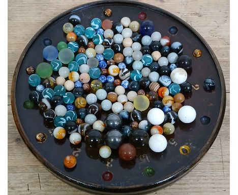 A tray of assorted marbles, glass, hard stone and metal, various designs.