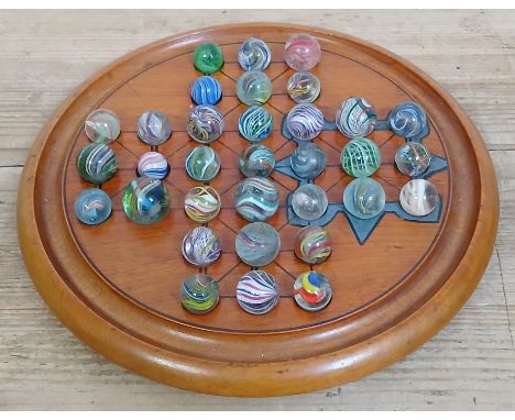 A solitaire board containing 33 hand blown glass marbles including latticino, lobed core swirls, ranging in diameter from app