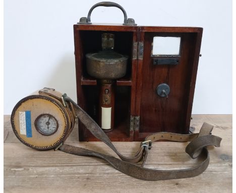 A hand held bearing compass with wooden box and a leather cased night watchman's clock.