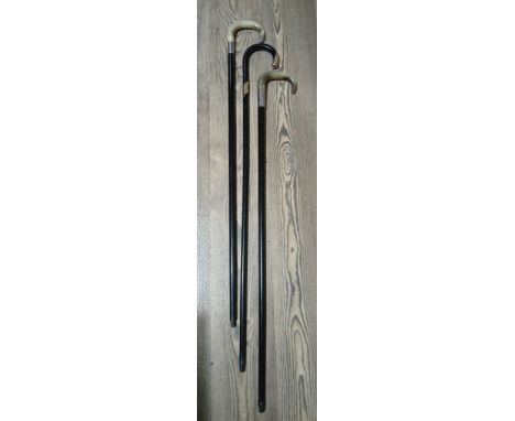 Three antique walking sticks comprising two horn handled and silver mounted, and a gold plated mounted stick.