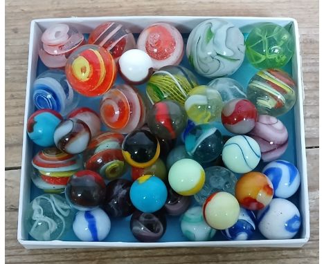 A collection of assorted glass marbles including Akro corkscrews etc, ranging in diameter from approximately 15mm to 27mm.