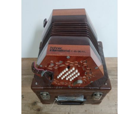 A Hohner International C 48/96/6L concertina squeeze box with associated hard case.Condition:- General wear throughout with n