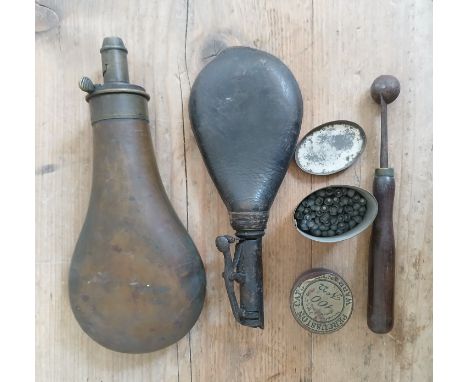 A shot flask, powder flask, powder scoop, percussion caps, etc.