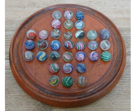 A solitaire board containing 33 hand blown glass marbles, various designs, ranging in diameter from approximately 12mm to 17m