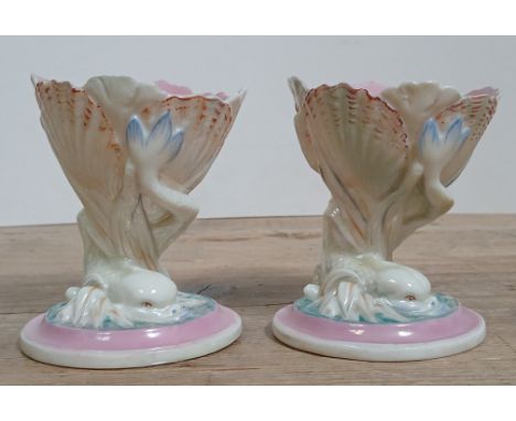 A pair of Worcester porcelain pedestal salts, each modelled as a mythical dolphin holding clams, height 10.5cm.Condition - go