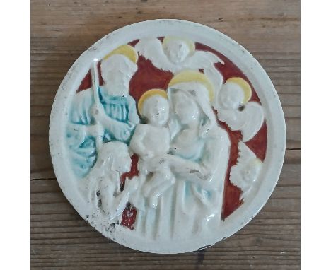 A Della Robbia plaque depicting a the baby Jesus, Joseph and MAry with surround angels, impressed marks verso, diameter 12.5c