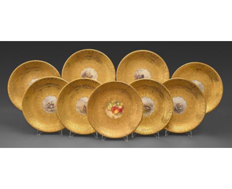 A set of seven Royal Worcester plates, 1925, painted by Jas Stinton, signed, with birds reserved on a richly gilt acid-etched