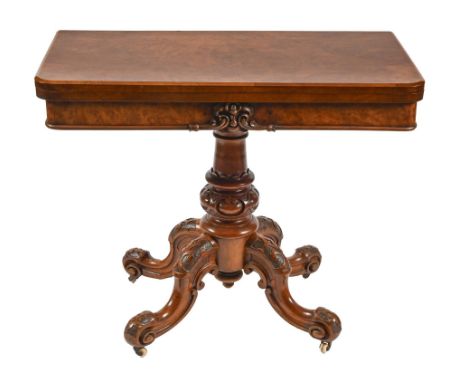 A Victorian walnut card table, the fold-over baize lined top in matched butterfly veneers, on carved pillar and quadruple leg
