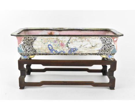 A Chinese Canton enamel jardiniere on wooden base, painted with cartouches to each side depicting naturalistic scenes with bi
