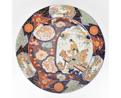 A large early 20th century Japanese imari porcelain charger, with figural and mythical vignettes featuring a dragon and phoen