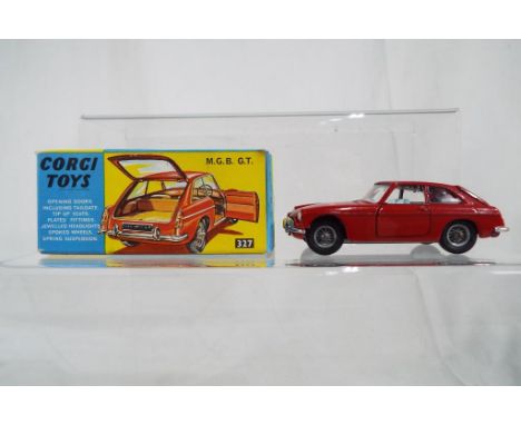 Corgi Toys - M.G.B G.T # 327. Dark red body with pale blue interior, spoked wheels, jewelled headlights, suitcase. Model appe