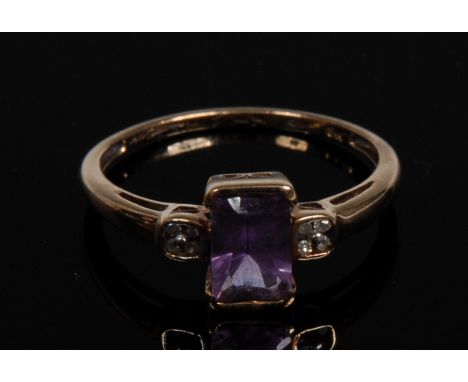 An amethyst and diamond nine stone ring, central octagon amethyst. 0.95ct, flanked by two flower head clusters of four diamon