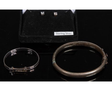 A silver hinge bangle; a child's bangle; a pair of paste silver stud earrings (3)