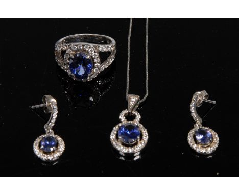 A four piece dress jewellery suite comprising, a blue and white cubic zirconia cluster dress ring, pendant and earrings, 925 