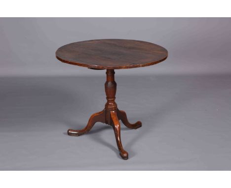 A GEORGE III OAK TILT-TOP TRIPOD TABLE, with circular top and turned stem continuing to pad feet. 67cm by 77cm