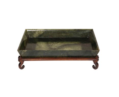 A CHINESE JADE SHALLOW BOWL, rectangular, spinach coloured, on a wooden stand. Bowl 21.5cm by 15cm