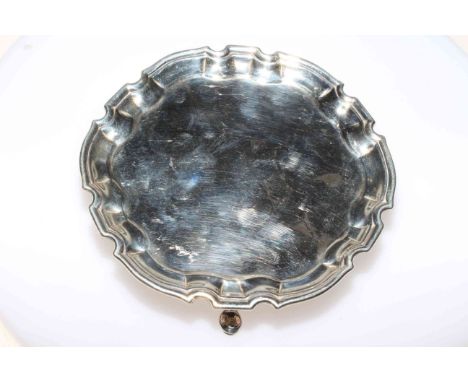 Small Georgian silver card tray raised on three pad feet in Chippendale style, 15cm diameter.