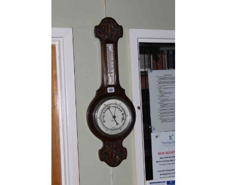 Carved oak barometer-thermometer with silvered dial.