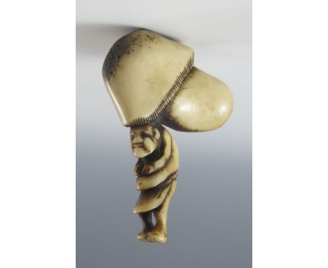 Netsuke. Mann trägt Riesenpilz auf dem Kopf. Hirschhorn. Mitte 19. Jh. H 5,4 cm