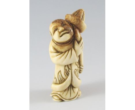 Netsuke. Stehender Holländer trägt runden Hut auf einem Stock. Hirschhorn. Himotoshi im Rücken. Mitte 19. Jh. H 5,9 cm