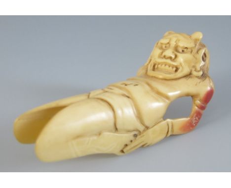 Netsuke. Oni, hohl geschnitzt aus einem Vogelschnabel. Auf der Rückseite des Kopfes zwei kleine Himotoshi. 2. H. 19. Jh. L 7 