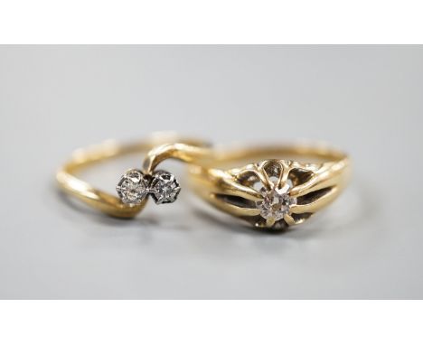 An early 20th century 18ct gold and claw set solitaire diamond ring, size O and an 18ct &amp; Pt, two stone diamond set cross