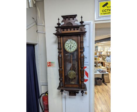 A late 19th century Austrian walnut wall clock, with key and pendulum, height 118cm