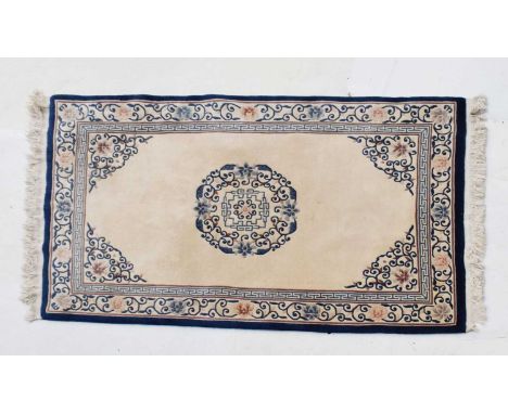 Two Chinese wool rugs, the first with cream ground and blue scroll decoration, 245cm x 153cm, the second with sea green groun