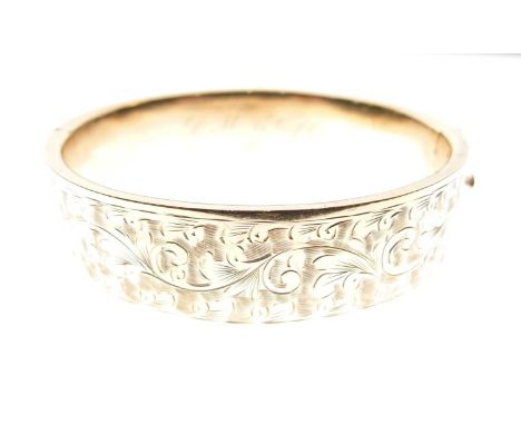 9ct gold snap bangle of hollow design, one half engraved externally, 17mm wide x interior of 58mm x 48mm approx, 19g approx