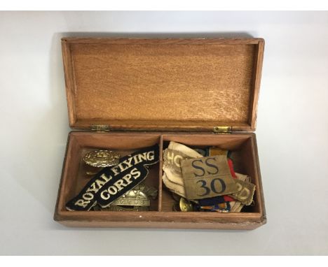 Wooden box containing cap badges, buttons, together with Royal Flying Corps shoulder patch, LDV part arm band etc.