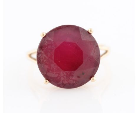 A 9ct yellow gold treated ruby ring, set with a round cut treated ruby (possibly glass filled), diameter approx. 14mm, hallma