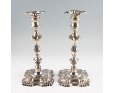 A pair of Edwardian silver weighted candlesticks, the knopped stem and foot featuring fluted design, both hallmarked London 1