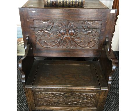 An oak monk’s bench with carved panel to back with the green man.