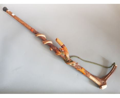 A carved folk art walking stick dated 1979, with carved adder wasp, lizard and fly decoration, and working whistle with deer 