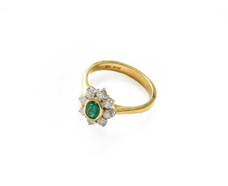 An 18 carat gold emerald and diamond cluster ring, finger size OThe ring is in good condition however there is a surface reac