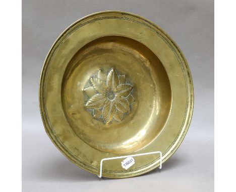 A 17th/18th century brass alms bowl, the centre is decorated with a repousse rosette, the borders with ring turned edge and f