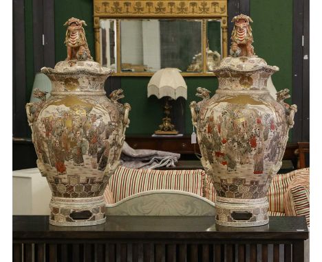 A pair of large early 20th century Japanese satsuma vases with twin dragon and ring handles, decorated with figures and with 