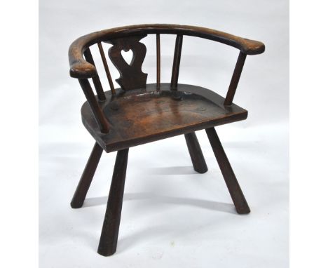 A primitive oak chair, the single piece seat with pierced heart shaped splat and hoop back, raised on rough hewn legs Conditi