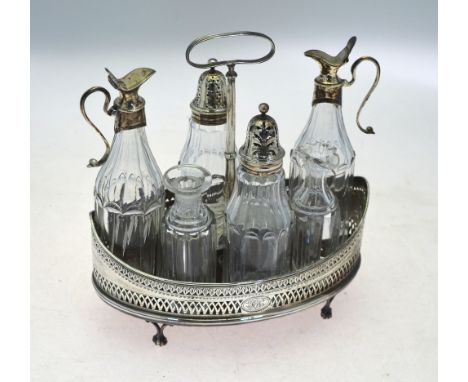 A George III silver cruet stand of eliptical form with engraved and pierced sides, loop handle, shaped divider and claw and b