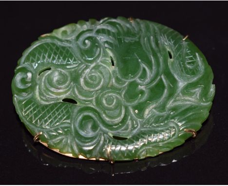 A 9ct gold brooch set with carved nephrite jade depicting a dragon, 12.4g, 4.3 x 3.2cm